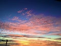 BRIGHT PINK FLEECY CLOUDS AMIDST A STRIKING BLUE BACKDROP OF SKY. A SILHOUETTE OF A LONELY CRANE. Royalty Free Stock Photo