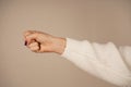 The bold gesture conveys a powerful message of unity or defiance. Set against a neutral background, the focus remains on