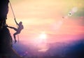 Bold heroic man try to climb with rope over natural rocky wall wide valley autumn sunset mountain Royalty Free Stock Photo