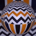 black white and orange gold zigzag pattern with reflections in a glass sphere Royalty Free Stock Photo