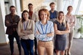 Bold and outgoing group of successful business people, looking at camera with team leader in front . eye contact