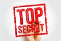 A bold red TOP SECRET stamp with a distressed texture, presented as if held or applied by a hand, symbolizing confidentiality, Royalty Free Stock Photo