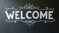 Bold Welcome in block letters on chalkboard with decorative flourishes Royalty Free Stock Photo