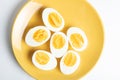 Bolied half-cut pieces of eggs on yellow plate