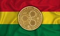 Bolivia flag, ripple gold coin on flag background. The concept of blockchain, bitcoin, currency decentralization in the country.