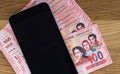 Bolivian currency, One hundred Bolivianos banknotes lying together with a mobile phone on the wooden table