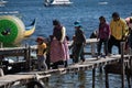 A bolivian family walk through a wooden pier in Copacabana, Bolivia