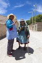 Bolivian woman helping senior to walk in the street of Rosario,