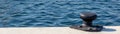 Bollar on pier with blue water in background Royalty Free Stock Photo