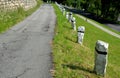 Mountain road with traditional white stone bollards with a black stripe. Old stone pillars of granite stone perched on the lawn