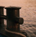 Bollard close-up on the pier with a piece of rope.