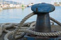 Bollard from iron with a ship rope at the pier on the port Royalty Free Stock Photo