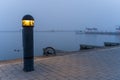 Bollard light in a harbor on a misty morning