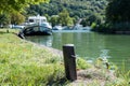 A bollard at the Lutzelbourg Locaboat station in the Marne-Rhine Canal with ships out of focus in background