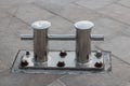 A bollard made of corrosion-resistant steel is installed on the pier of the seaport. Royalty Free Stock Photo