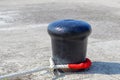 Bollard with a rope for mooring ships in the port Royalty Free Stock Photo