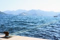 Bollard roped tied on the dock of blue sea water Royalty Free Stock Photo