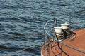 Bollard on ship deck with metal mooring lines.