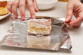 BOLO GELADO is a traditional Brazilian cake - Wrapping the cake with coconut sprinkles in aluminum foil. Front view Royalty Free Stock Photo