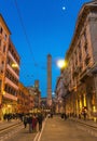 Bologna, Italy, March 17, 2019: many people walking down the street to two medieval towers