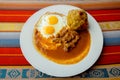 Bolon de verde with fried egg and meat stew