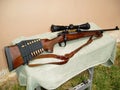 A bolt-action hunting rifle is on a white table