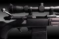 bolt action rifle with riflescope close up on black background, copy space