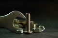 Bolt nuts and wrench on cement floor in darkness. Royalty Free Stock Photo