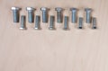 Bolts for industrial work gear at wooden background with copy space for your own text