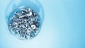 Bolts nuts and washers of different sizes in a glass bowl on a blue background Royalty Free Stock Photo