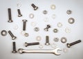 Bolts, nuts, washers and wrench on a gray background Royalty Free Stock Photo