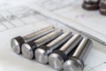 Bolts after turning with thread on the background of technical drawings Royalty Free Stock Photo