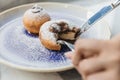 Bombolone is an Italian filled doughnut and is eaten as a snack food and dessert with hands cutting Royalty Free Stock Photo