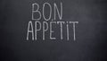 Bon Appetit phrase written on blackboard, high-end restaurant advertisement