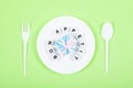 Bon appetit text on round white plate with gift box, spoon, fork on green background. Festive, birthday, Gift pastel minimal