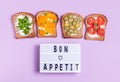 Bon appetite lettering with vegetarian vegetable sandwiches with cream cheese on purple background