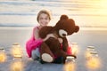 Bonding with bear at the beach. Portrait of a cute little girl playing with her teddy bear on the beach. Royalty Free Stock Photo