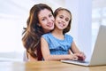 Bonding and browsing. Portrait of a mother and daughter using a laptop together at home. Royalty Free Stock Photo