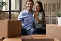 Bonding couple sit on couch holding keys celebrate moving day