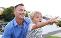 Bonding, father and child in garden pointing with excited, smile and outdoor view in backyard. Happy man, son and