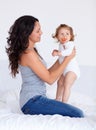 Bonding, sweet and mother playing with baby on bed in morning together at family home. Happy, smile and young mom having Royalty Free Stock Photo