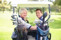 Bonding together on the golf course. Golfing companions on the golf course in a golf cart. Royalty Free Stock Photo