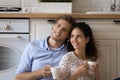 Young married couple dream at kitchen hold cups with tea