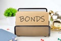 BONDS text on paper next to piggy bank, notepad, flower on a white background Royalty Free Stock Photo