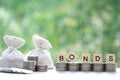 Bonds word on stack of coins money and a bag on natural green background, Investments and Bonds increasing concept