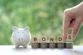 Bonds word on stack of coins money and piggy bank natural green background, Investments and Bonds increasing concept