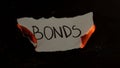 Bonds word written on white paper burns. Fire with smoke and ashes on black background Royalty Free Stock Photo