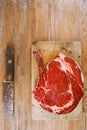 Bone-in Rib eye Steak steak on paper and wooden table Royalty Free Stock Photo