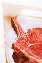 Bone-in Rib eye Steak steak on paper and wooden table Royalty Free Stock Photo