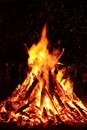 Bonfire. Big orange flame on a black background. Fire on black. Bright, warm, light, camping, big fire. Flying sparks of fire. Royalty Free Stock Photo